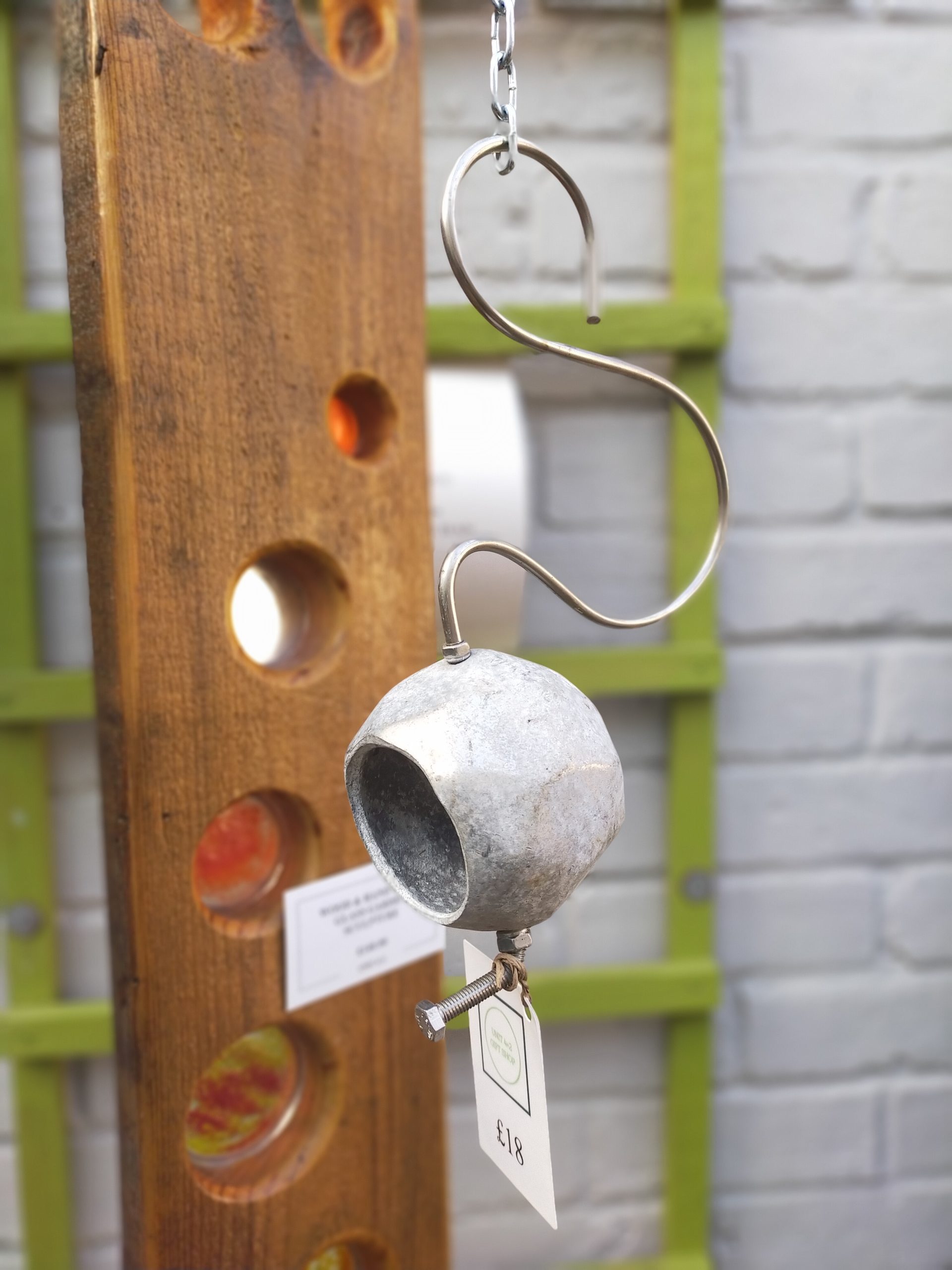 Small metal globe bird feeder with twisted metal hook.